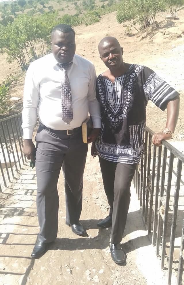 Two leaders standing on a dry rural hillside