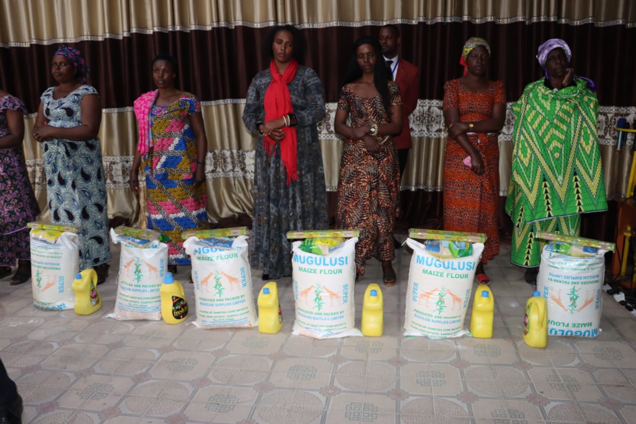 Women standing with maize flour and cooking oil prepared for families