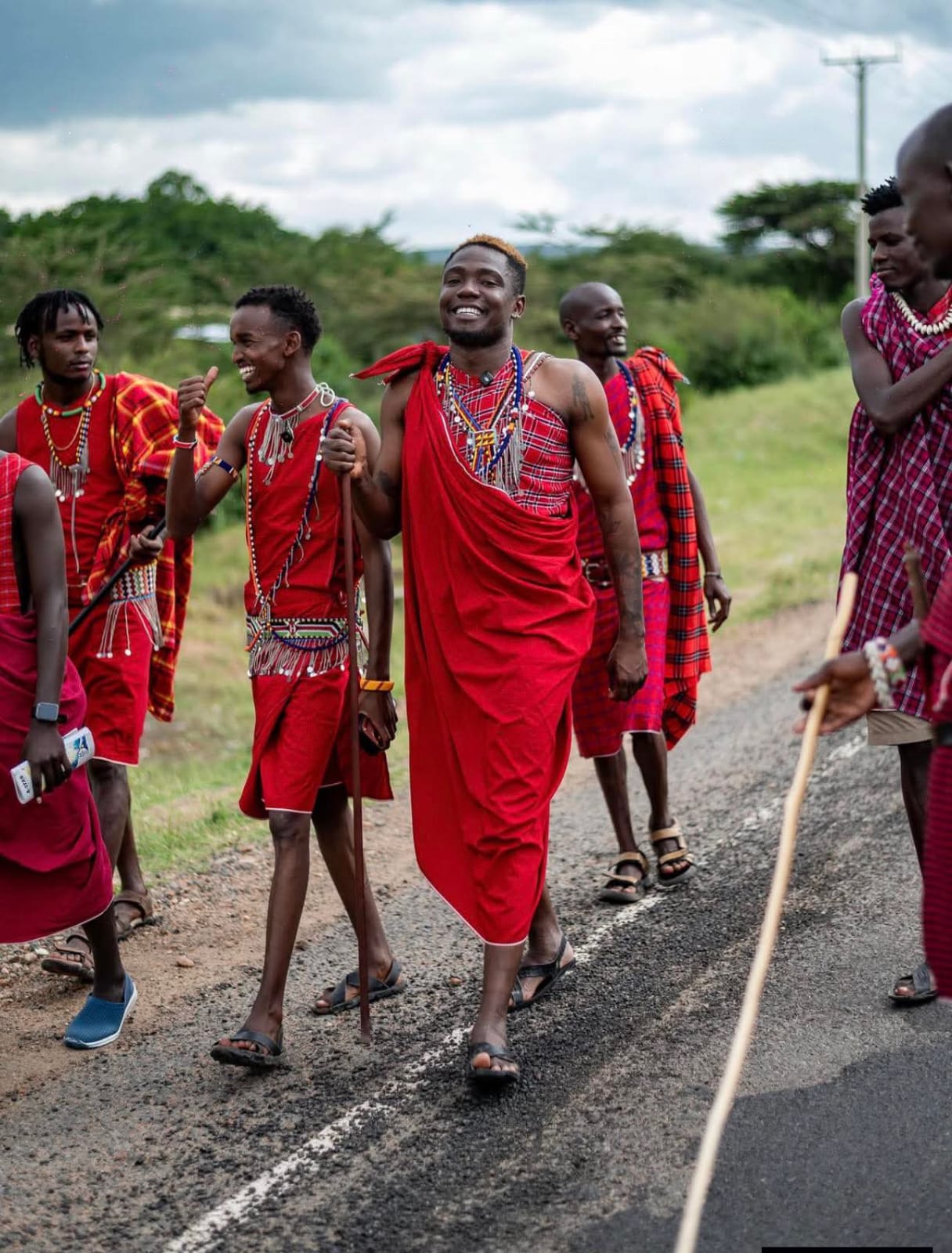Community members in traditional dress walking together during an outreach visit